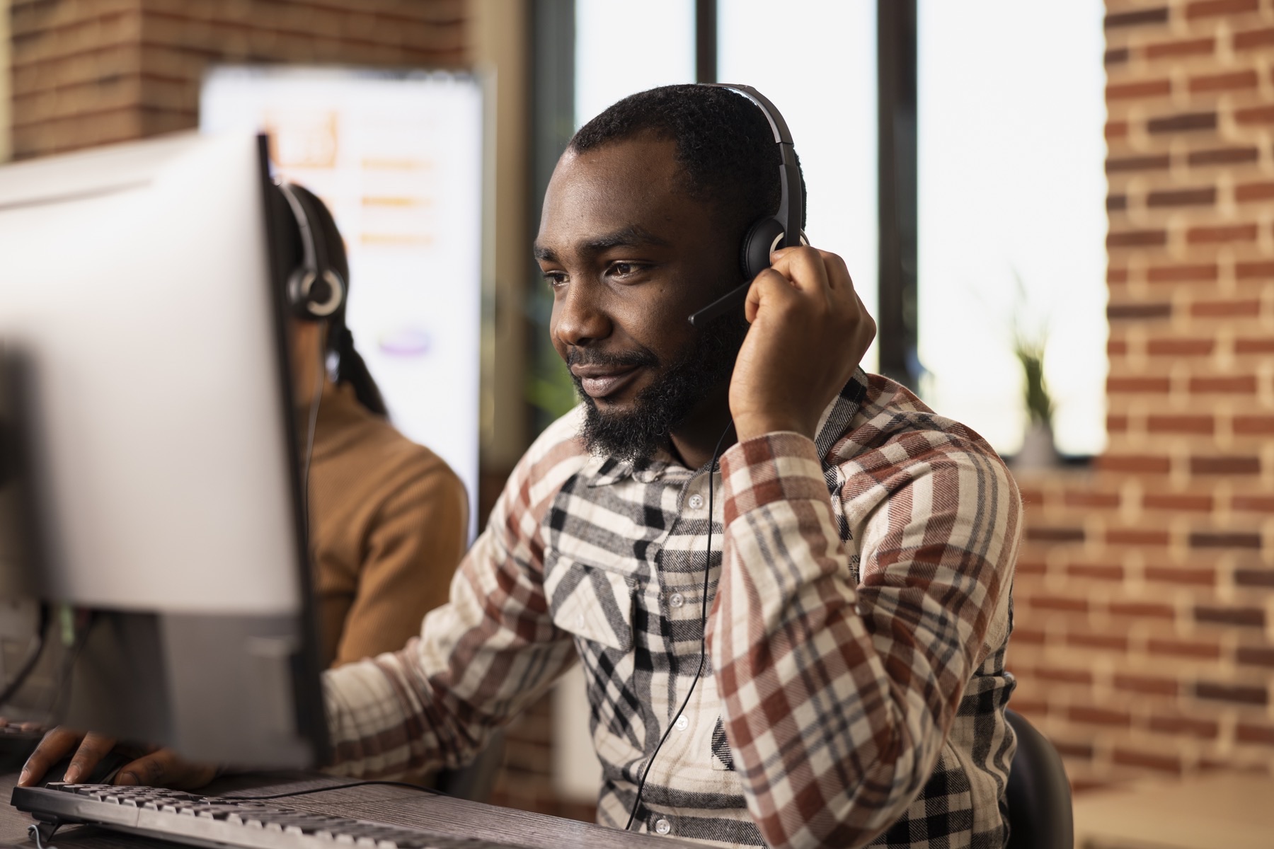 A professional speaking with a client while using a computer